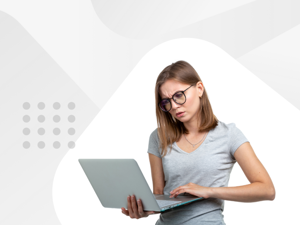 Woman wearing glasses typing on laptop computer.